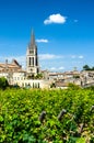 Bell tower of Saint-Emilion monolithic church through the vineyards.