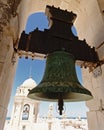 Bell in a tower of the Santa Cruz cathedral of Cadiz, with the city and sea in the background