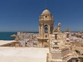 Bell tower of the Santa Cruz cathedral of Cadiz, with the city and sea in the background