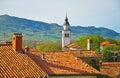 The bell tower and tiled roofs, mountains in the background Royalty Free Stock Photo