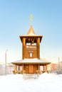 Bell tower wooden church of logs in winter on a sunny day Royalty Free Stock Photo