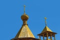 The bell tower of a wooden Orthodox Christian church. Crosses on the main dome and on the roof of the bell tower.