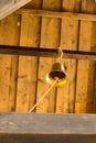 Bell yellow on the background of a wooden cover rustic bell tower. Vertical photo of a tall wooden tower
