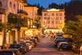 Bellagio. Lake Como. Night Time Street in Bellagio with Tourists, Cars and Lights of Outdoor Lanterns