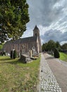 Bellem , East-Flandres, 09 18 2022 : A view on the catholic church with a walkway along the cemetary