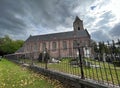 Bellem, Flandres, Belgium 09 18 2022 : View on a catholic chruch and cemetary against a clouded sky