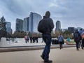 Group of people walking around in the park in downtown Bellevue near the ice rink, the city skyline in the background Royalty Free Stock Photo
