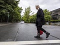 Bellevue, WA USA - circa June 2021: View of an older woman with long, white hair crossing the street in downtown Bellevue on an