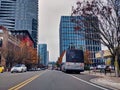 Street view of bus and car traffic and buildings in Bellevue, WA, on a calm afternoon