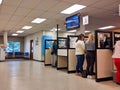 People renewing license ID at counter at the DMV