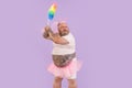 Bellicose actor man with overweight in fairy suit holds dust brush on purple background