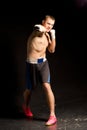 Belligerent young boxer throwing a punch Royalty Free Stock Photo