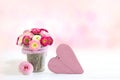 Bellis in glass vessel and heart as a greeting for Mother`s Day