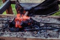 Bellows inflate the fire in the coals. Blacksmith heats iron for forging