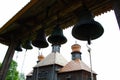 Bells near the church. Massive cast-iron prayer bells against the backdrop of a Christian Orthodox wooden church. Ancient catholic