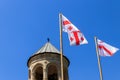 Bells tower of Svetitskhoveli Cathedral and Georgian flag against blue sky in Mtskheta, Georgia Royalty Free Stock Photo