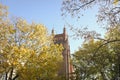 Belltower of an Anglican Church among yellow leaves. Sunny autumn view. Royalty Free Stock Photo