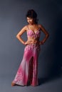 Belly dancer performing belly dance in the ethnic pink costume for dancing on gray background Royalty Free Stock Photo