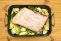 Belly of pork resting on a trivet of vegetables