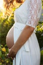 Belly of pregnant girl in garden with grapes Royalty Free Stock Photo