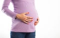 The belly of a pregnant girl which she holds with her hands on a white background, isolate. Abdominal bloating in Royalty Free Stock Photo