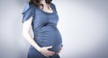 Belly of pregnant woman in blue clothes