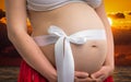 Belly of a pregnant woman with bowknot