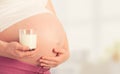 Belly of pregnant woman and glass of milk Royalty Free Stock Photo