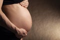 Belly of a pregnant woman in profile in soft colors