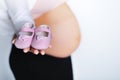 Pregnant woman with little shoes in her hand