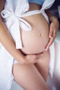 Belly of pregnant woman in white dress Royalty Free Stock Photo