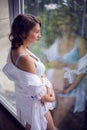 Belly of pregnant woman in white dress Royalty Free Stock Photo