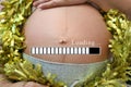 Belly of pregnant women and loading text in concept of time in c Royalty Free Stock Photo