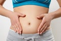 Belly of a young woman in the early stages of pregnancy. on white