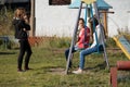 Teen girls communicate on the playground with cellphones in their hands in the courtyard of a residential building Royalty Free Stock Photo