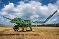 Belogorye, Khmelnytsky region, UKRAINE - August 19, 2021: John Deere sprayer fertilizes, rear view