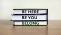 Belong symbol. Books with words `be here, be you, belong` on beautiful wooden table, white background. Business, belonging and