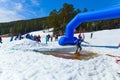 BELORETSK,RUSSIA, 13 APRIL 2019 - a man snowboarder passes through a pool filled with water on the ski track in the Ural mountains Royalty Free Stock Photo