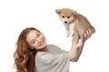 Cheerful redhead young girl with long curly hair holding cute little puppy of corgi dog isolated on white background