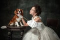 Beloved pet. Young beautiful woman in image of medieval person in renaissance style dress with little cute dog Royalty Free Stock Photo