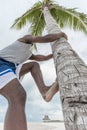 African American man climbing palm Royalty Free Stock Photo