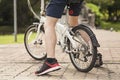 Below body of young man stopped by at public park with his bicycle.