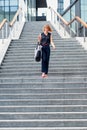 Stylish woman walking down stairs
