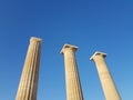 From below shot of magnificent ancient pillars standing against cloudless blue sky on sunny day.