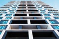 From below shot of modern and new apartment building. Photo of a tall block of flats against a blue sky. Royalty Free Stock Photo