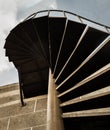 Below view of Brown metal spiral staircase pattern with iron railing in front of brick textured wall Royalty Free Stock Photo