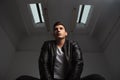 Below view of young man in leather jacket posing seated Royalty Free Stock Photo