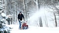 BEMIDJI, MN - 22 JAN 2019: Man works with a snow blower to remove newly fallen snow.