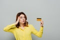 bemused woman touching head while holding