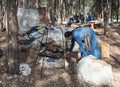 The reconstruction participant of the `Viking Village` kindles a fire in the hearth in the camp in the forest near Ben Shemen in I